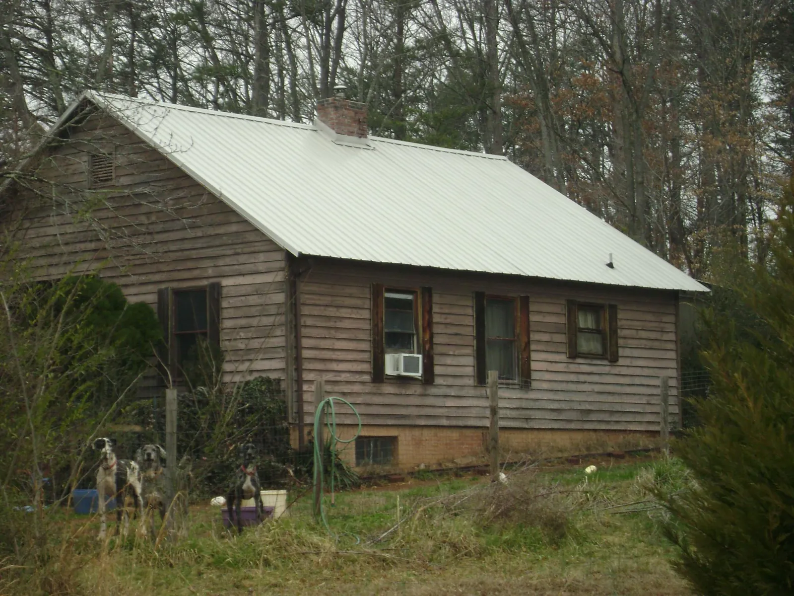 White metal roof on an old wood sided farmhouse, from a Metal Roof Installation job in Deer Creek